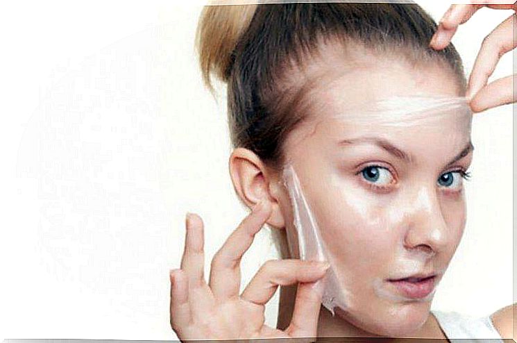 Woman taking off mask against open pores.