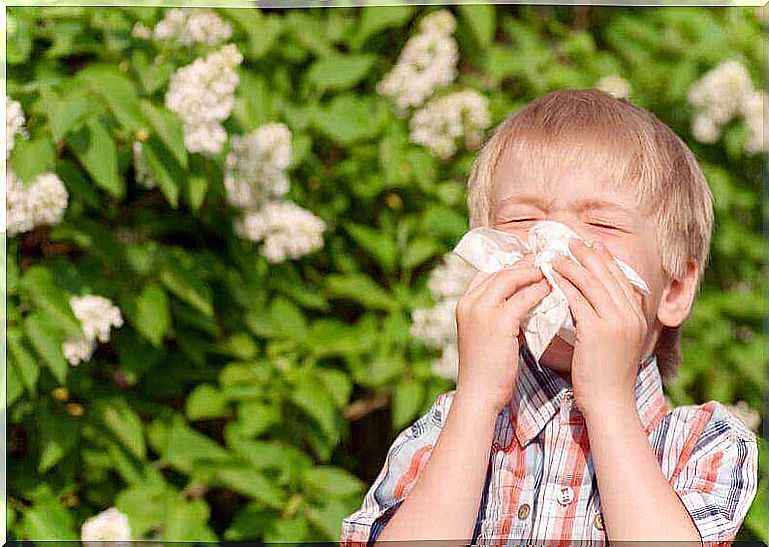 boy with childhood allergy sneezing